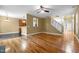 Spacious living room with hardwood floors, ceiling fan, and view of kitchen and staircase at 2067 Glenkirk Dr, Burlington, NC 27215