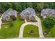 Stunning aerial view of a brick home with a circular driveway and manicured lawn in a lush, green neighborhood at 209 Bailey Ridge Dr, Morrisville, NC 27560