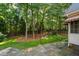 Lush green backyard featuring mature trees and a stone patio at 209 Bailey Ridge Dr, Morrisville, NC 27560