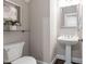 Charming half-bathroom with a pedestal sink, framed artwork, and a plant accent at 209 Bailey Ridge Dr, Morrisville, NC 27560