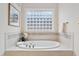 Bathroom featuring soaking tub, white tile, and glass block window at 209 Bailey Ridge Dr, Morrisville, NC 27560