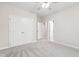 Neutral bedroom with a ceiling fan, carpeted floor, and double doors at 209 Bailey Ridge Dr, Morrisville, NC 27560