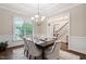 Formal dining room with a chandelier, large window and an adjacent staircase at 209 Bailey Ridge Dr, Morrisville, NC 27560