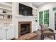 Living room showcasing a brick fireplace, built-in shelving, and natural light at 209 Bailey Ridge Dr, Morrisville, NC 27560