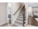 Staircase featuring carpeted steps, a wooden handrail, and iron balusters at 209 Bailey Ridge Dr, Morrisville, NC 27560
