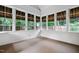Bright sunroom featuring neutral paint, a carpeted floor, and multiple windows offering a serene view at 209 Bailey Ridge Dr, Morrisville, NC 27560