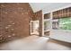 Spacious sunroom with brick accent wall, multiple windows, and door to an additional room at 209 Bailey Ridge Dr, Morrisville, NC 27560
