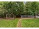 Spacious backyard with a mature trees, lush green lawn, and a dog run ready for your furry friends at 2724 Glastonbury Rd, Apex, NC 27539