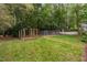 View of lush backyard featuring multiple fenced areas, and a firepit at 2724 Glastonbury Rd, Apex, NC 27539