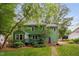 Green two-story home with a well-maintained yard, deck, and surrounding trees at 2724 Glastonbury Rd, Apex, NC 27539