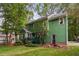 Green two-story home with a well-maintained yard, deck, and surrounding trees at 2724 Glastonbury Rd, Apex, NC 27539