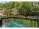 Green wooden deck overlooks backyard with lush trees and fenced areas at 2724 Glastonbury Rd, Apex, NC 27539
