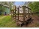 Unique backyard with custom wooden structure surrounded by trees and green grass at 2724 Glastonbury Rd, Apex, NC 27539