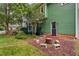 Green painted deck leads to a patio with fire pit and seating in the spacious backyard at 2724 Glastonbury Rd, Apex, NC 27539