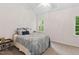 Bright bedroom featuring a comfortable bed with stylish blue bedding and a ceiling fan at 2724 Glastonbury Rd, Apex, NC 27539