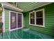 View of the green wooden deck and purple framed glass doors surrounded by green painted exterior siding at 2724 Glastonbury Rd, Apex, NC 27539
