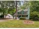 Two-story green home featuring a well-maintained front yard and a detached white garage in the background at 2724 Glastonbury Rd, Apex, NC 27539