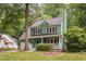 Charming green house with a purple door, lush green lawn, and mature trees at 2724 Glastonbury Rd, Apex, NC 27539