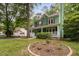 Charming green home with a detached white garage and landscaped front yard at 2724 Glastonbury Rd, Apex, NC 27539