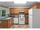 Traditional kitchen with wooden cabinets, tiled backsplash, and white appliances at 2724 Glastonbury Rd, Apex, NC 27539