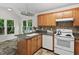 Well-lit kitchen featuring ample counter space, wooden cabinets, and a garden view window at 2724 Glastonbury Rd, Apex, NC 27539