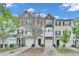 Charming townhomes boast diverse facades, attached garages, and landscaped front yards under a bright blue sky at 3027 Courtney Creek Blvd, Durham, NC 27713