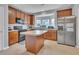 Open kitchen boasts stainless steel appliances, wood cabinets, and a center island for cooking convenience at 3027 Courtney Creek Blvd, Durham, NC 27713