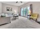 Bright living room with neutral tones, cozy seating, and double doors to outdoor space at 3027 Courtney Creek Blvd, Durham, NC 27713