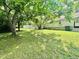 Grassy backyard with mature trees surrounding the home at 304 Sandalwood Ave, Louisburg, NC 27549