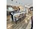 Kitchen island with barstool seating featuring granite counters and modern pendant lighting at 304 Sandalwood Ave, Louisburg, NC 27549