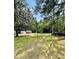 Wide shot of the sprawling yard with mature trees and storage sheds at 304 Sandalwood Ave, Louisburg, NC 27549