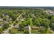 An aerial view of a property shows a well-maintained lawn, mature trees and the surrounding neighborhood at 305 Oakgrove Dr, Graham, NC 27253