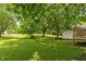 The backyard is green and spacious, featuring mature trees that offer plenty of shade and greenery at 305 Oakgrove Dr, Graham, NC 27253