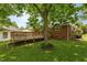 The backyard features a wooden deck, grassy lawn and mature shade trees at 305 Oakgrove Dr, Graham, NC 27253