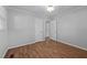 Bedroom with new wood flooring, neutral walls, and closet and doorway at 305 Oakgrove Dr, Graham, NC 27253