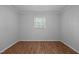 This bedroom offers hardwood floors, neutral walls and a window at 305 Oakgrove Dr, Graham, NC 27253