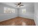 Well-lit bedroom with hardwood floors, wainscoting and multiple windows offering a bright and airy feel at 305 Oakgrove Dr, Graham, NC 27253