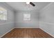 This bedroom offers wood plank flooring, neutral walls, and a ceiling fan at 305 Oakgrove Dr, Graham, NC 27253