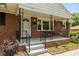 Inviting front porch with a charming porch swing, wrought iron railings, and attractive brick accents at 305 Oakgrove Dr, Graham, NC 27253