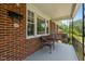 Cozy porch with wicker seating, a porch swing, and views of the surrounding neighborhood at 305 Oakgrove Dr, Graham, NC 27253