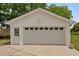 Detached two car garage with white exterior, and two entry points at 305 Oakgrove Dr, Graham, NC 27253