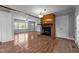 Open-concept living room featuring hardwood floors, a brick fireplace, and abundant natural light at 305 Oakgrove Dr, Graham, NC 27253