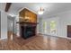 Bright living room featuring a brick fireplace, wood paneling, and access to the backyard through glass doors at 305 Oakgrove Dr, Graham, NC 27253