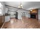 Open floor plan with hardwood floors, a rustic beam, kitchen, and a brick fireplace, perfect for gathering at 305 Oakgrove Dr, Graham, NC 27253