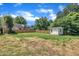 Large backyard with a white shed and a wood fence on a sunny day at 305 W Canary St, Dunn, NC 28334