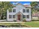 Charming two-story home featuring board and batten siding, a stone front porch, and a red front door at 305 W Canary St, Dunn, NC 28334