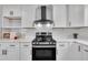 Modern kitchen showcasing stainless steel range, white cabinets, subway tile backsplash, and quartz countertops at 305 W Canary St, Dunn, NC 28334