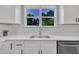 Stylish kitchen featuring a stainless steel sink, white cabinets, and a bright window overlooking greenery at 305 W Canary St, Dunn, NC 28334
