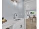 A wet bar with a white quartz countertop, stainless steel sink, and custom fixtures at 305 W Canary St, Dunn, NC 28334