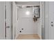 Bright utility closet with washer/dryer hookups, modern light fixture, and shelving at 3088 Colony Rd # A, Durham, NC 27705